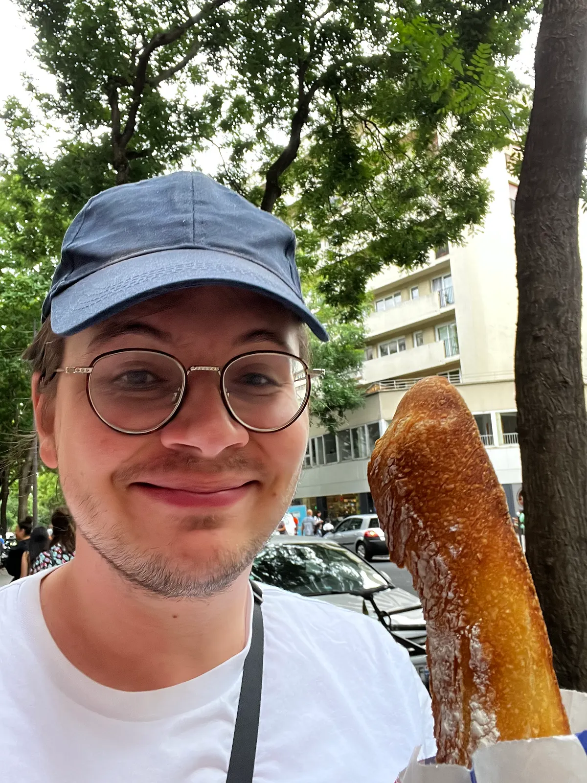 Simon holding a baguette in a Paris street